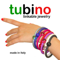 Arm with multiple TUBINO MURANO linkable BRACELETS in array of fashion colors, luxurious hypoallergenic synthetic rubber with handmade murano glass links, easily cut to size, Made in Italy