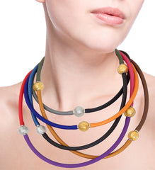 Model wearing multiple TUBINO SPARKLE linkable fashion NECKLACES luxurious hypoallergenic synthetic rubber with stainless steel link handmade gold-leaf and silver-leaf murano glass link, easily cut to size, Made in Italy