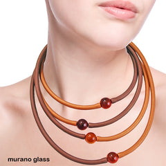 Model wearing multiple TUBINO MURANO linkable NECKLACES in gold and bronze, luxurious hypoallergenic synthetic rubber with handmade murano glass links, easily cut to size, Made in Italy