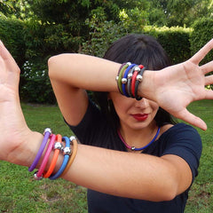 Model wearing multiple TUBINO SPORTIVO linkable fashion BRACELETS in array of colors, luxurious hypoallergenic synthetic rubber with nickel-free metal links, easily cut to size, Made in Italy